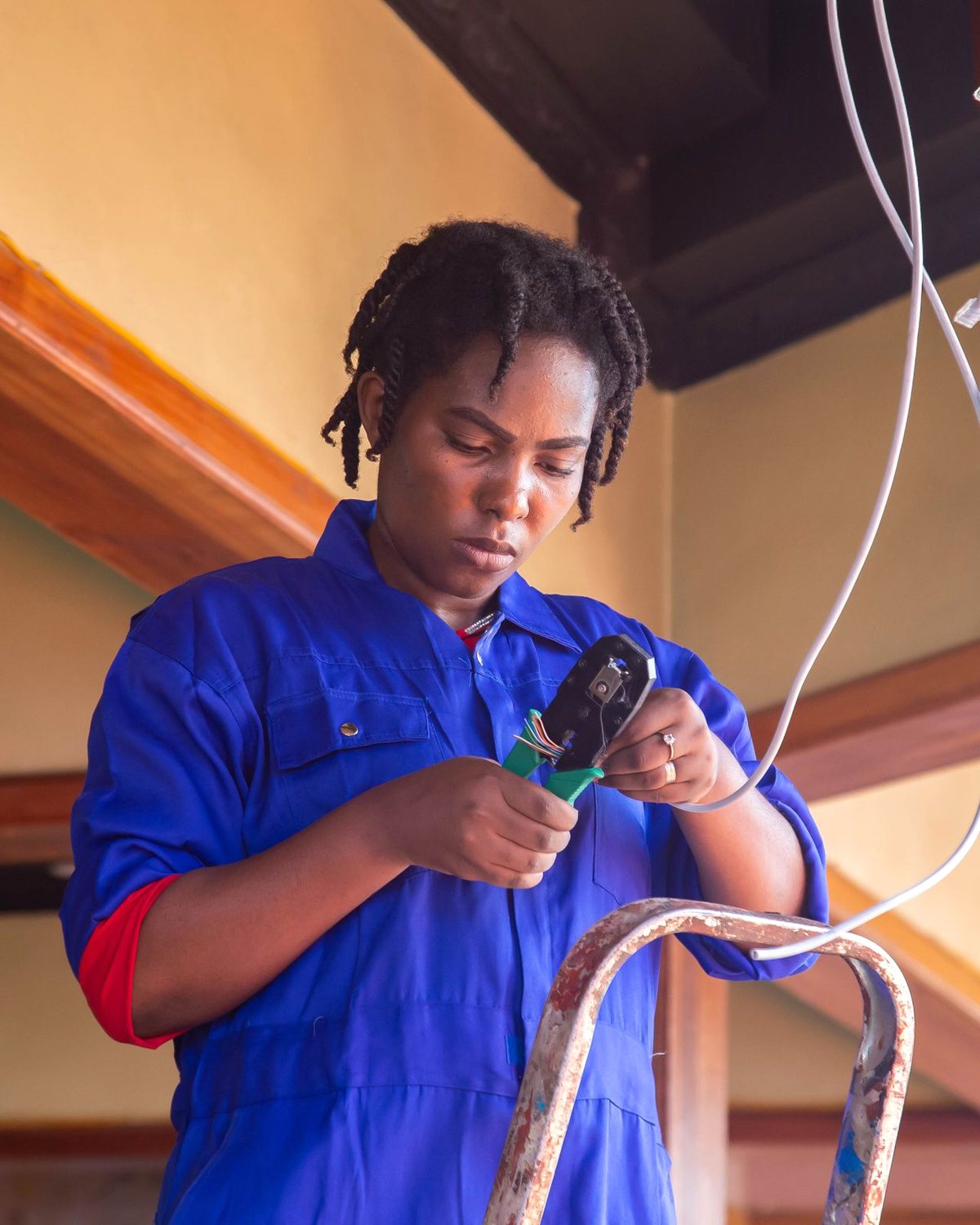 A Handyman Services electrician stripping a cable while wiring a fitting